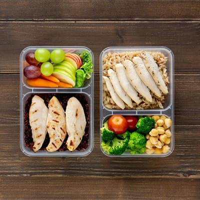 兩份健康餐盒，包含雞胸肉、蔬菜、米飯和水果，營養均衡的餐點。